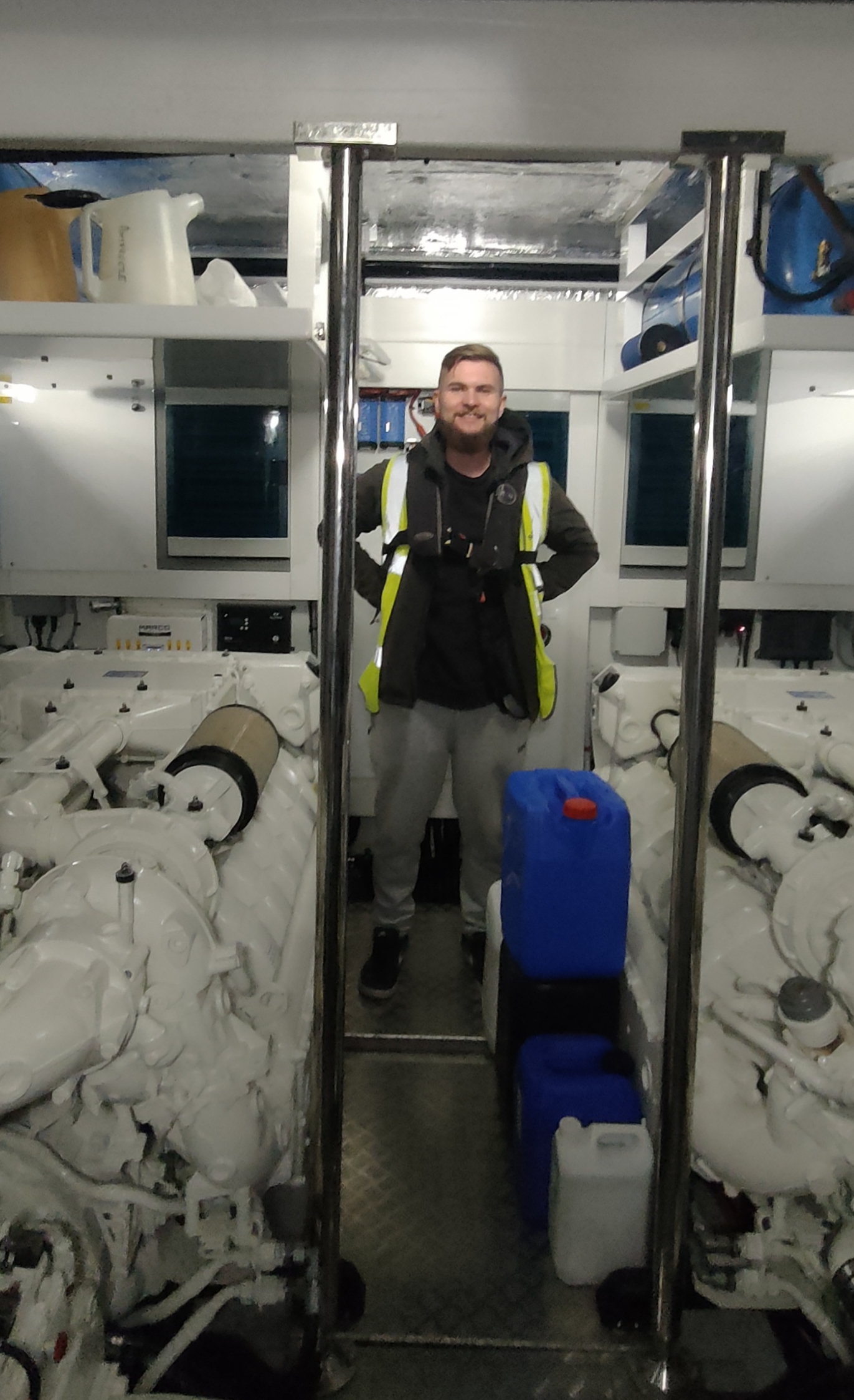 A picture of a man standing in the engine bay of a boat.